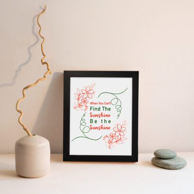 Infidu When You Can't Find The Sunshine Be The Sunshine wall art with a white background and red floral accents and black frame displayed on the wall Inspiring decor for home offices.