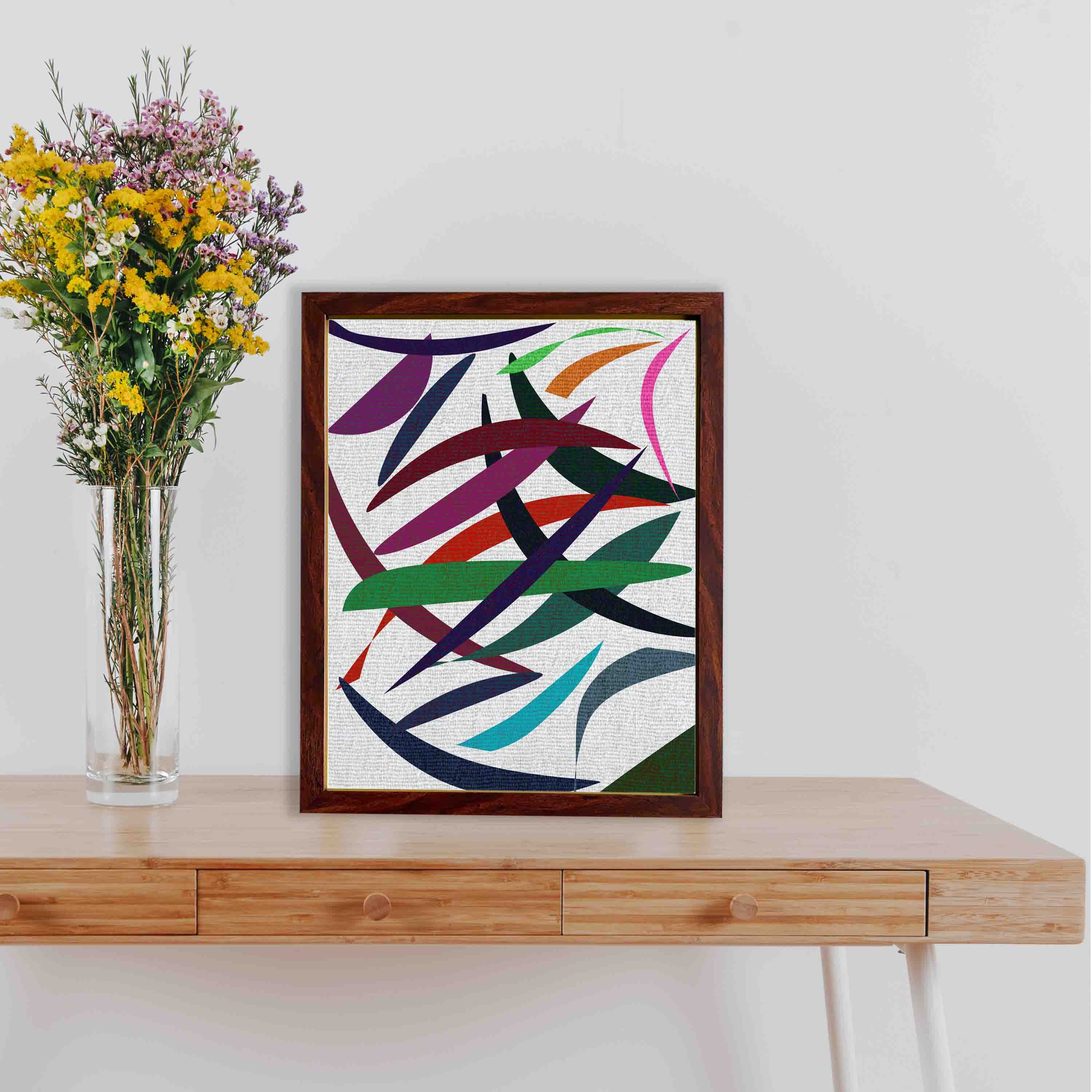 Abstract wall art with overlapping red, green, blue, purple, and pink shapes on a textured white background, framed in dark brown wood.