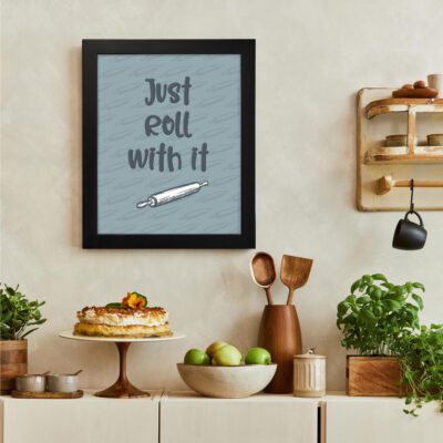 Infidu Just Roll With It - Kitchen Wall Art with light blue background, casual text, and rolling pin design for modern kitchen decor. There is a vegetable table, and above it, there is wall art.