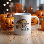 White coffee mug with a colorful taco illustration and the phrase "Wanna taco 'bout it?" in a playful, handwritten-style black font. Microwave-friendly espresso cup.