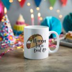 White coffee mug with a colorful taco illustration and the phrase "Wanna taco 'bout it?" in a playful, handwritten-style black font. Microwave-friendly espresso cup.