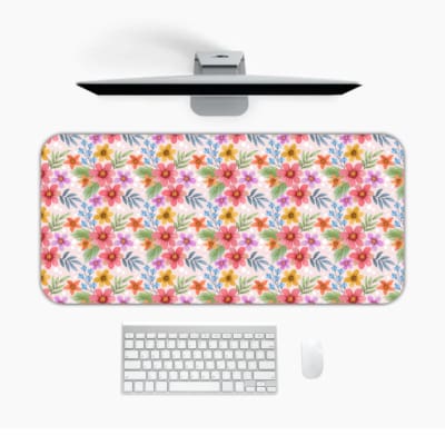 Light pink desk mat with a vibrant floral pattern featuring pink, red, and yellow flowers and blue leaves for a creative workspace touch. Desk Pad on the computer table