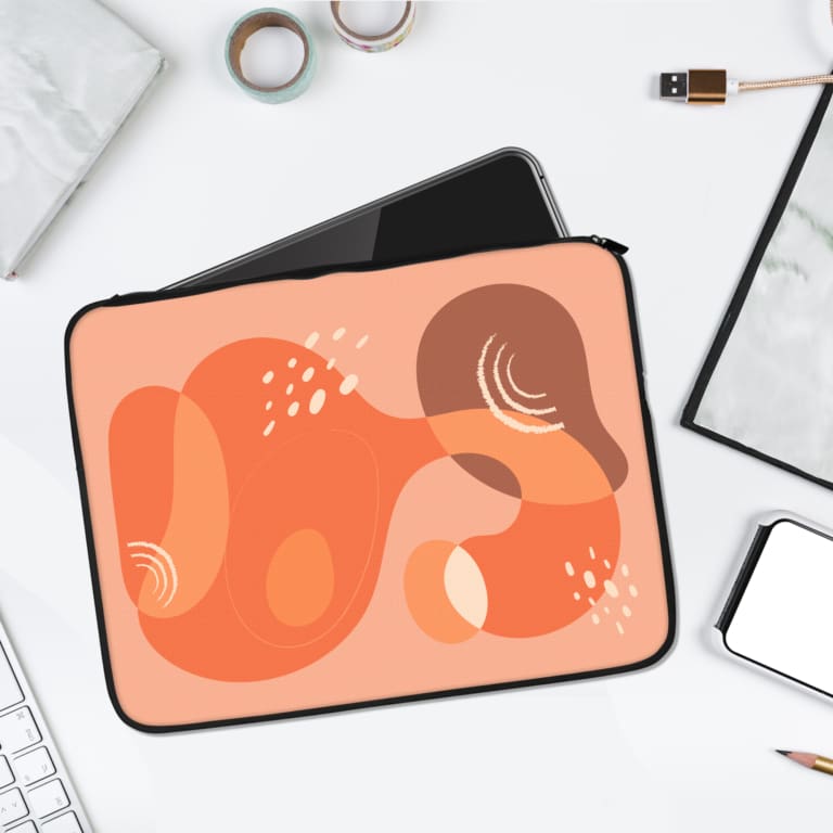 Abstract organic shapes laptop sleeve with vibrant pink, orange, and peach patterns, white dotted accents, and a durable zip closure. laptop sleeve kept on a plain white background