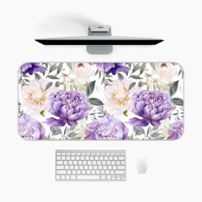 Infidu desk pad with colorful floral design on white background. Features large yellow and purple flowers with green and grayish leaves. A desk pad under the computer
