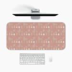 Infidu Beige Desk Mat with a subtle pattern of small shapes or icons on a soft beige background. A desk pad under the computer