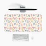 Desk pad with a light background featuring a colorful pattern of floral and abstract shapes in blue, pink, yellow, and green. A desk pad under the computer