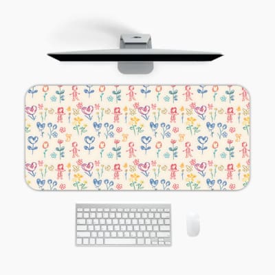 Desk pad with a light background featuring a colorful pattern of floral and abstract shapes in blue, pink, yellow, and green. A desk pad under the computer