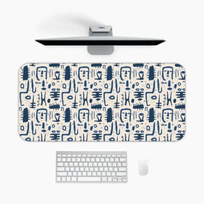 Blue abstract patterns including geometric shapes and faces on a white desk pad. A desk pad under the computer