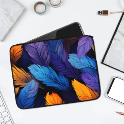 Laptop sleeve with a vibrant feather design in bold colors of blue, yellow, and orange, made from durable fabric with a secure zip closure. laptop sleeve kept on a plain white background