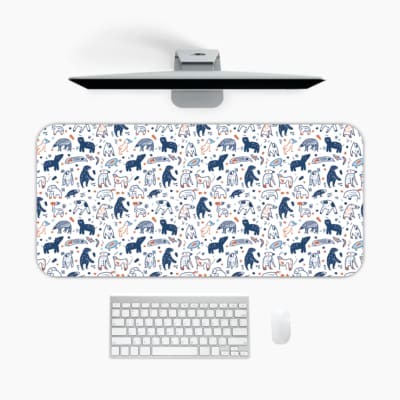 Desk pad with playful blue and dark blue bear patterns on a white background. A desk pad under the computer