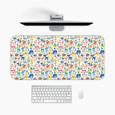 Desk pad with playful, colorful drawings of animals and plants on a white background. A desk pad under the computer