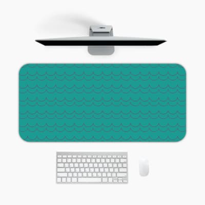 Desk pad with a turquoise green background and a subtle pattern. A desk pad under the computer