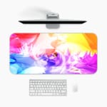 Infidu Vibrant Watercolor Design Desk Pad with abstract, colorful swirls of pink, orange, yellow, blue, and purple. A desk pad under the computer