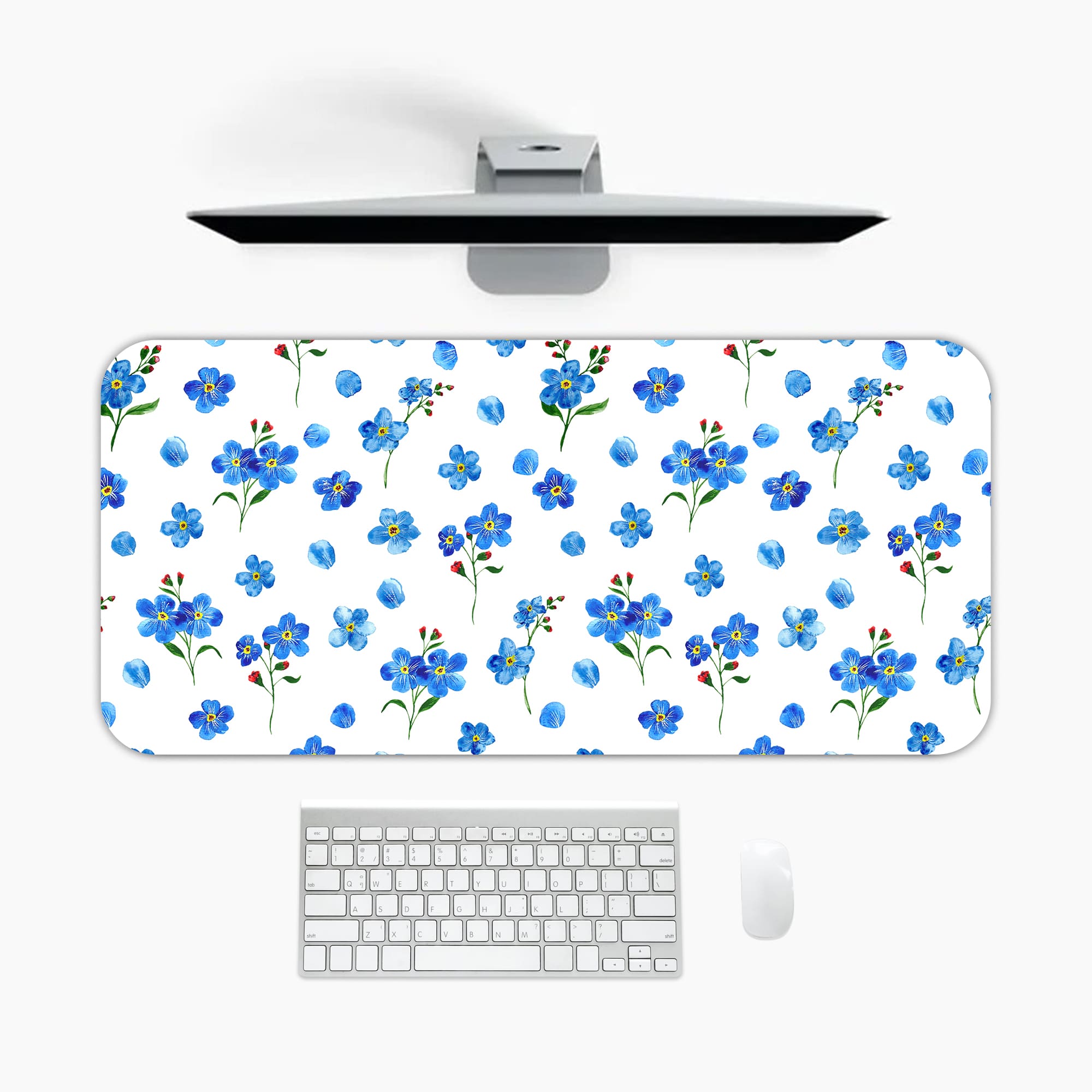 Desk pad with small blue flowers and dark green leaves on a white background. A desk pad under the computer