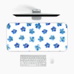 Desk pad with blue flowers evenly spaced on a white background. A desk pad under the computer