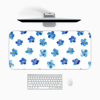 Desk pad with blue flowers evenly spaced on a white background. A desk pad under the computer