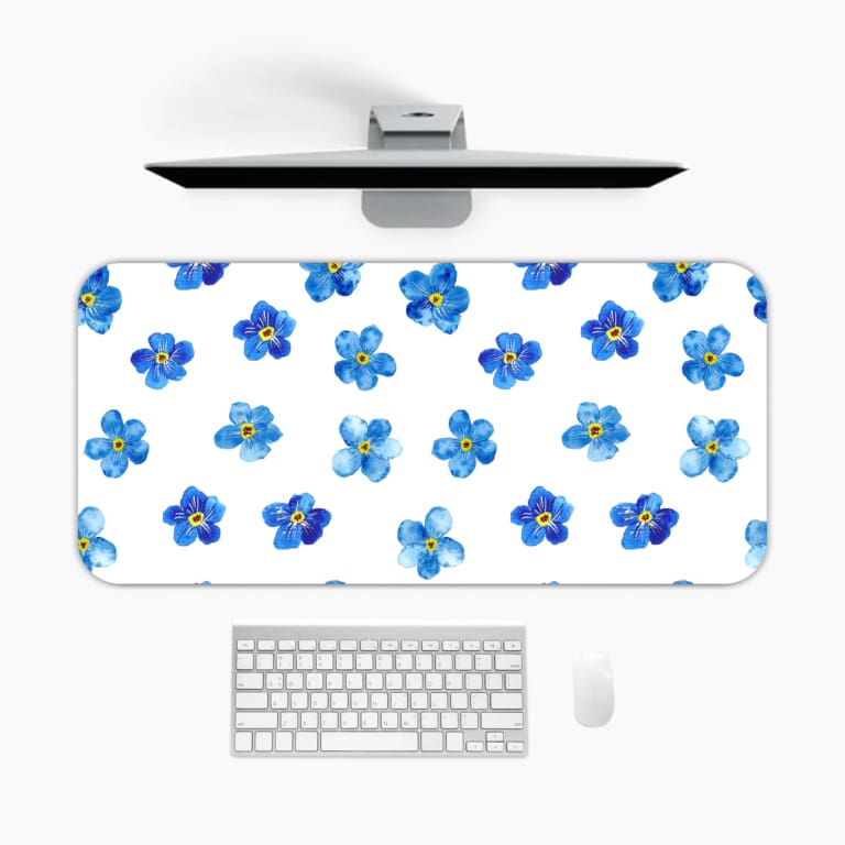 Desk pad with blue flowers evenly spaced on a white background. A desk pad under the computer