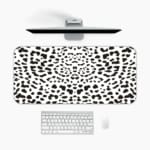 Infidu Black Leopard Print Desk Pad features a bold black leopard print pattern on a white background, offering a modern and stylish look. A desk pad under the computer
