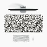 Infidu Black Leopard Print Desk Pad features a bold black leopard print pattern on a white background, offering a modern and stylish look. A desk pad under the computer