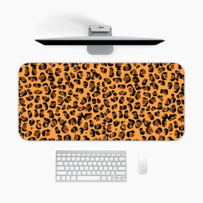 Infidu Leopard Print Design Desk Pad with black spots on a yellow background, simulating a leopard's natural fur. A desk pad under the computer