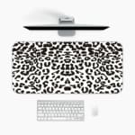 Infidu White Leopard Print Desk Pad features black spots on a white background, creating a classic and stylish leopard print design. A desk pad under the computer