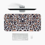 Infidu White Desk Pad with Bold Leopard Print Design featuring black and brown spots on a white background. A desk pad under the computer