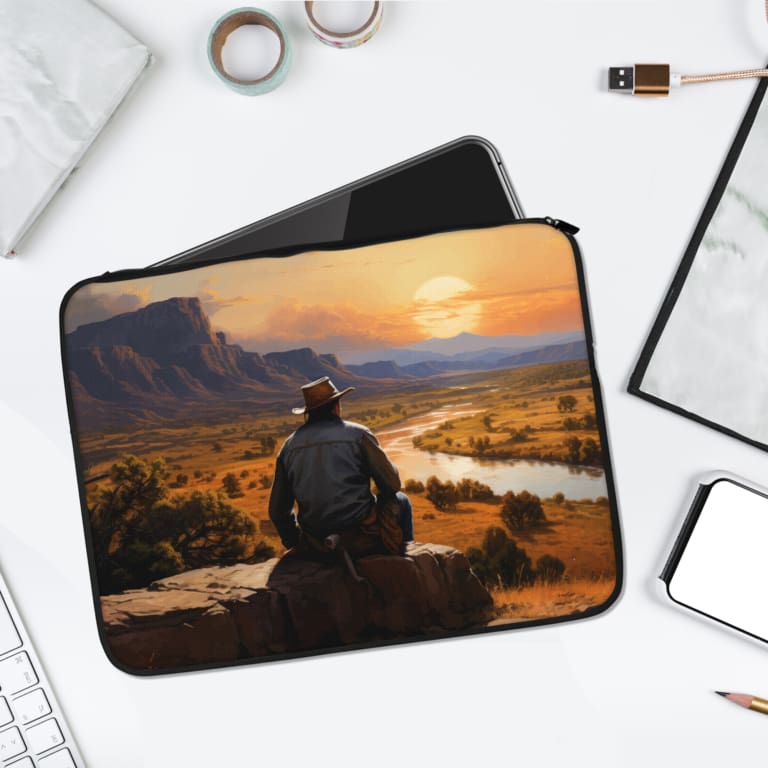Infidu Cowboy Outdoors Laptop Sleeve featuring a man in a cowboy hat overlooking a scenic river, with mountains and a sunset in the background. laptop sleeve kept on a plain white background