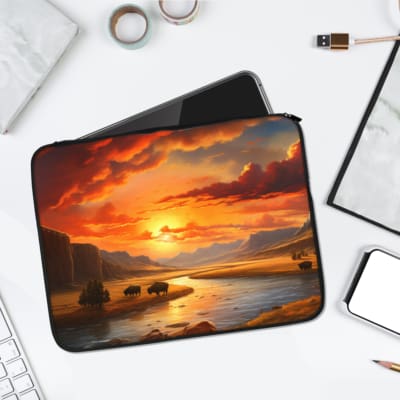 Sunset River Laptop Sleeve featuring a scenic design with a vibrant sunset over a calm river, trees, and cliffs in warm and cool tones. laptop sleeve kept on a plain white background