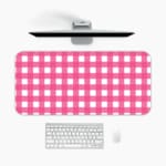 Pink and white checkered desk pad with a grid-like pattern on a white background. A desk pad under the computer