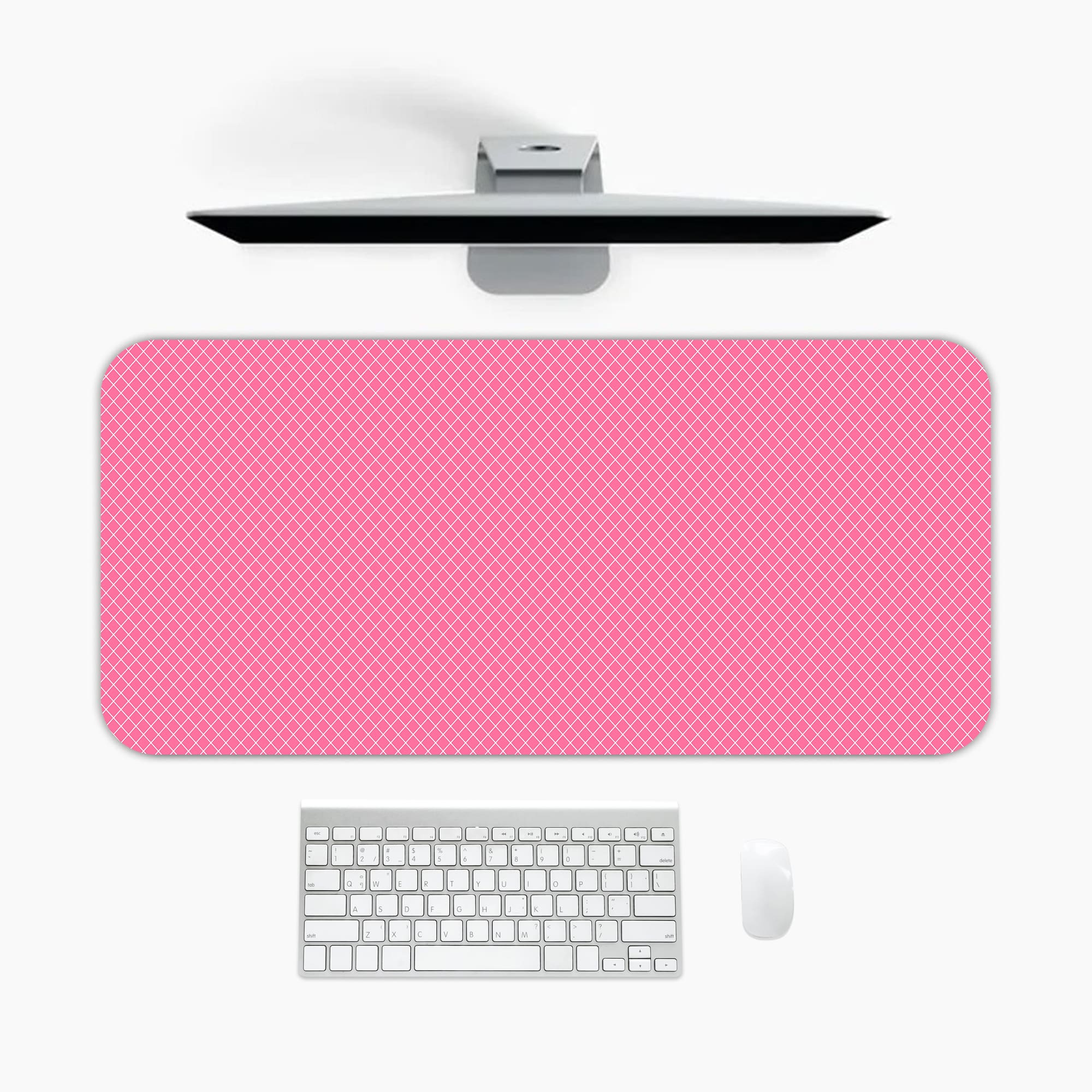 Bright pink desk pad with subtle dotted design, adding a textured look to a simple background. A desk pad under the computer
