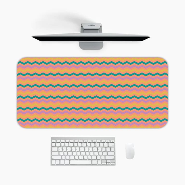 Desk pad with wavy lines in purple, green, and yellow on a light pink background. A desk pad under the computer