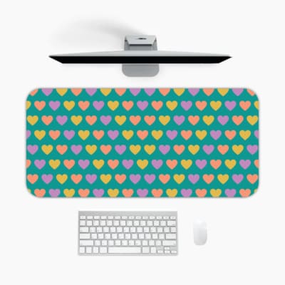 Infidu desk pad featuring colorful hearts in pink, yellow, and light purple on a teal background. A desk pad under the computer