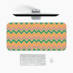 Infidu Teal and Purple Chevron Desk Pad with Peach Background featuring a zigzag pattern in vibrant teal and purple tones. A desk pad under the computer