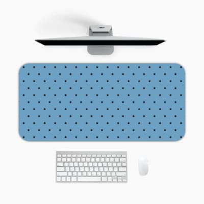 Desk pad featuring small black polka dots on a blue background. A desk pad under the computer