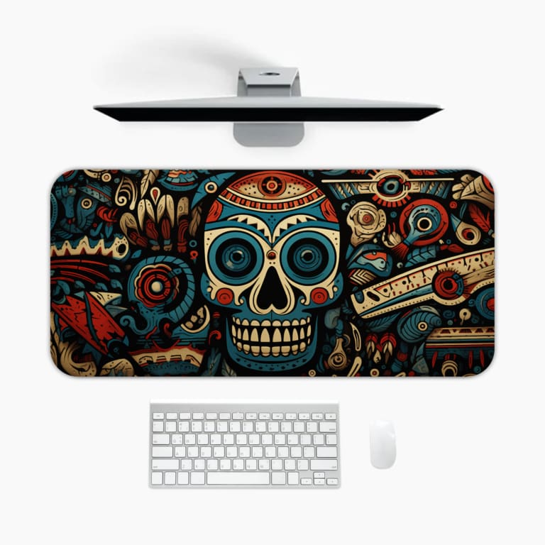 Desk mat with a colorful Day of the Dead skull design featuring intricate patterns in blue, red, white, and black. A desk pad under the computer