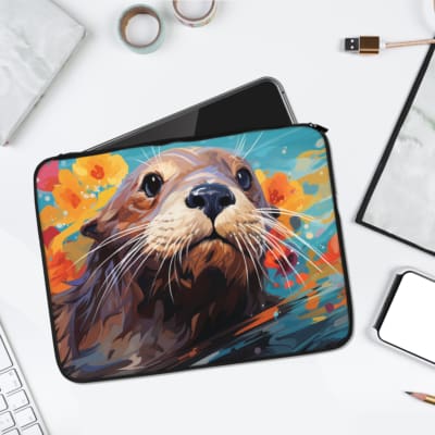 Playful otter face design on a vibrant laptop sleeve with an orange, blue, and yellow abstract background. laptop sleeve kept on a plain white background