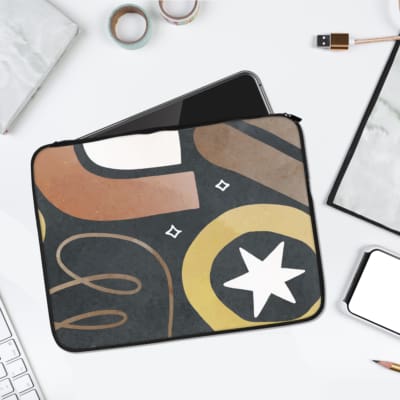 Bold artistic dark geometric laptop sleeve with a black background, circular motif, white star, and beige and brown patterns. laptop sleeve kept on a plain white background