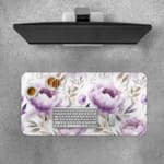 Infidu Soft Floral Desk Pad with white background, large purple and lavender flowers, and light gray and blue leaves. Desk Pad with Keyboard and Mouse on top of the desk pad