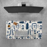 Blue tribal symbols desk pad with abstract patterns on a dim white background. Desk Pad with Keyboard and Mouse on top of the desk pad