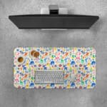 Desk pad with playful, colorful drawings of animals and plants on a white background. Desk Pad with Keyboard and Mouse on top of the desk pad