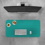Desk pad with a turquoise green background and a subtle pattern. Desk Pad with Keyboard and Mouse on top of the desk pad