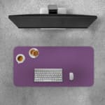Desk pad with a purple textured background and black diamond design. Desk Pad with Keyboard and Mouse on top of the desk pad
