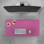 Pink desk pad with a pattern of small dots. Desk Pad with Keyboard and Mouse on top of the desk pad