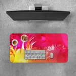 Desk pad with a vibrant pink and yellow abstract design. Desk Pad with Keyboard and Mouse on top of the desk pad