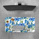 Blue floral desk pad with green leaves on a white background. Desk Pad with Keyboard and Mouse on top of the desk pad