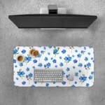 Desk pad with small blue flowers and dark green leaves on a white background.Desk Pad with Keyboard and Mouse on top of the desk pad