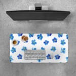 Desk pad with blue flowers evenly spaced on a white background. Desk Pad with Keyboard and Mouse on top of the desk pad