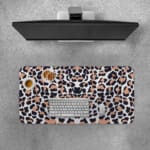Infidu White Desk Pad with Bold Leopard Print Design featuring black and brown spots on a white background. Desk Pad with Keyboard and Mouse on top of the desk pad