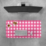 Pink and white checkered desk pad with a grid-like pattern on a white background. Desk Pad with Keyboard and Mouse on top of the desk pad
