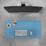 Desk pad featuring small black polka dots on a blue background. Desk Pad with Keyboard and Mouse on top of the desk pad